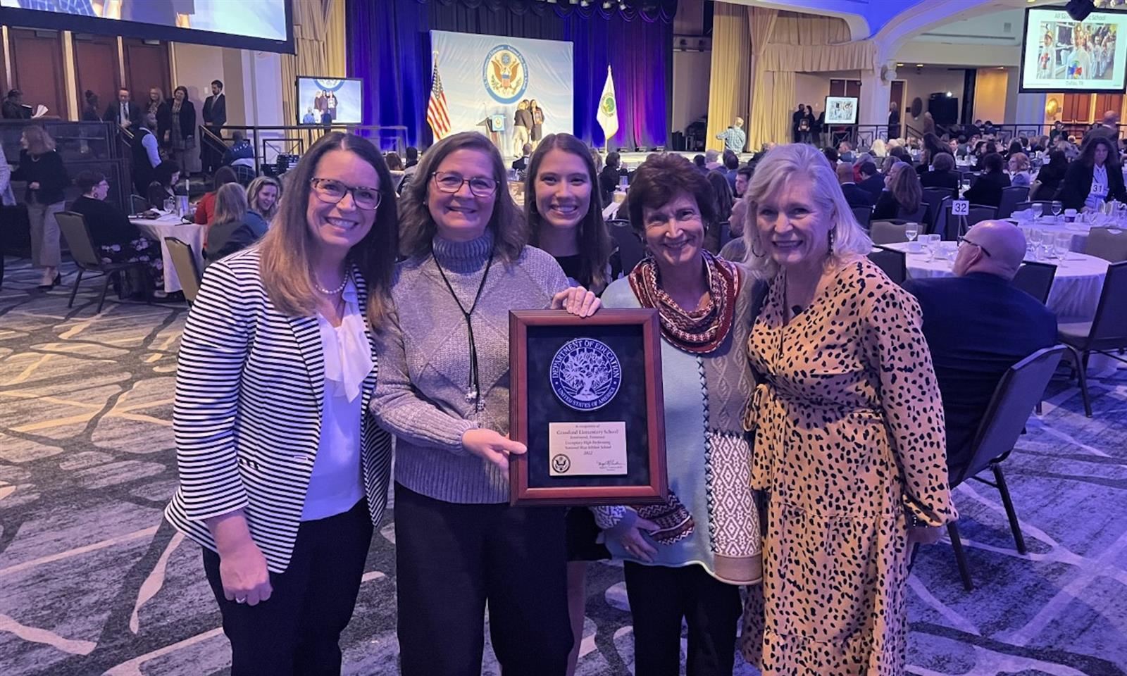 School staff hold an award plaque